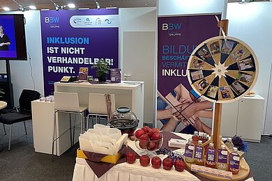 Messestand der BBW-Leipzig-Gruppe mit Roll-Ups, Glücksrad und Give-aways